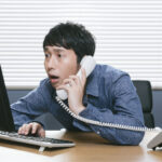 パソコンを前に驚いている人