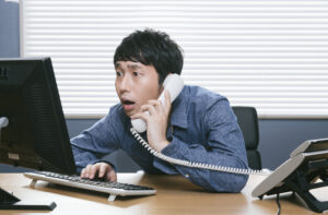 パソコンを前に驚いている人
